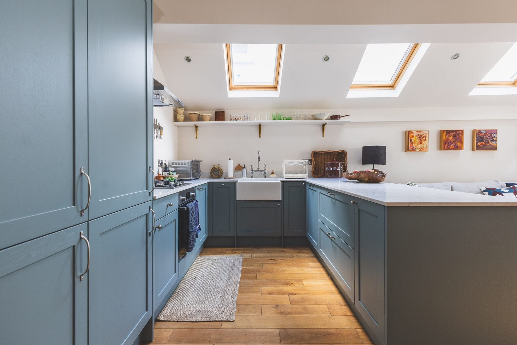 Blue fitted kitchen under a row of roof windows