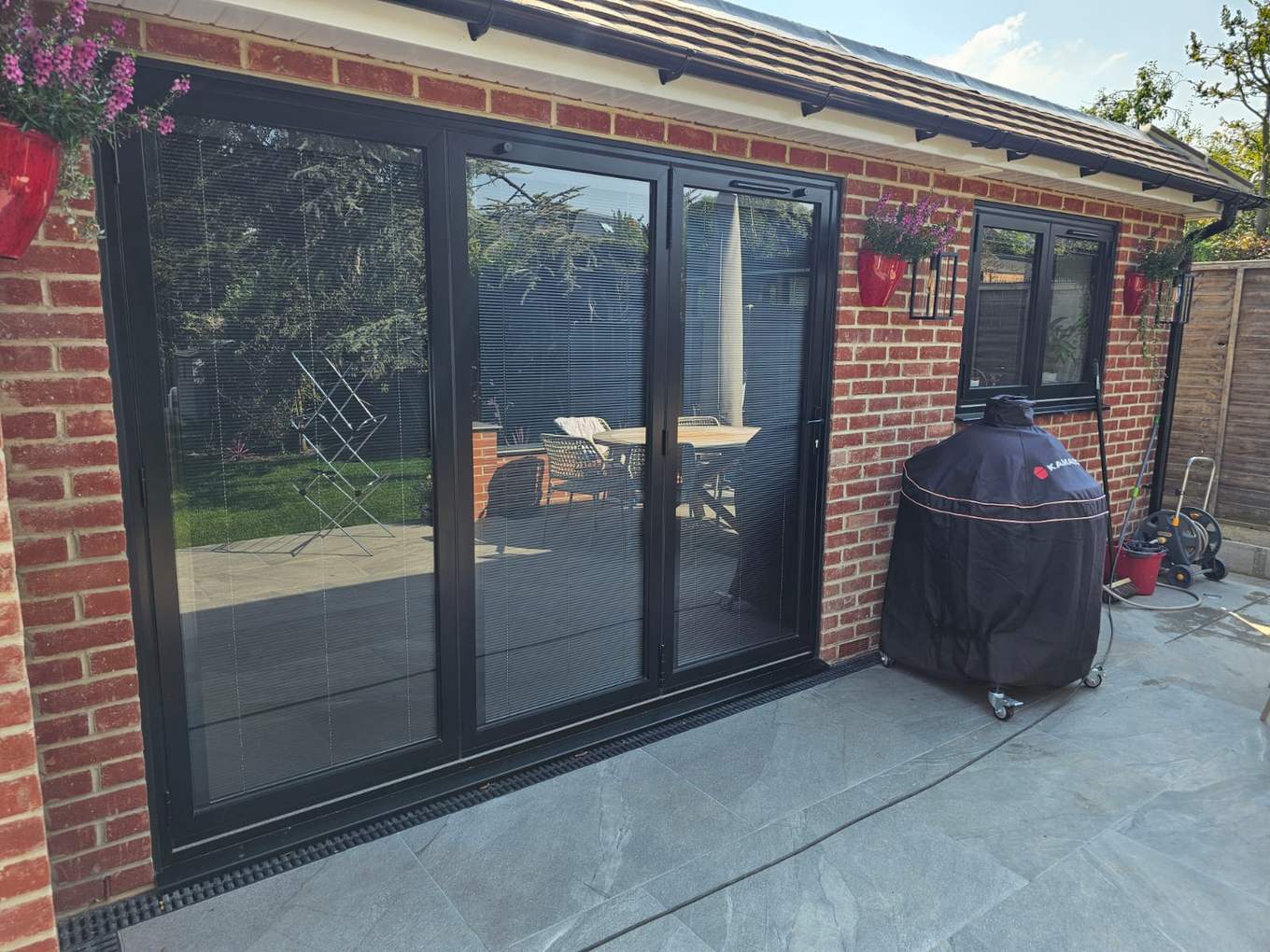 Black sliding patio doors on a red-brick extension