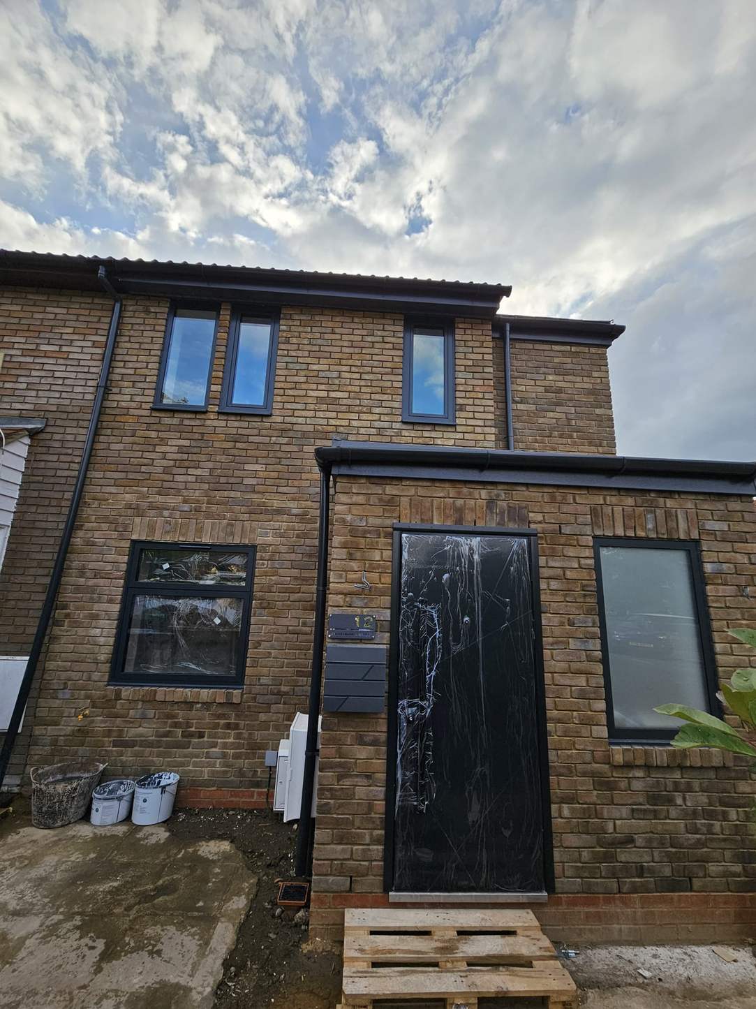 Brick extension with a black front door and windows