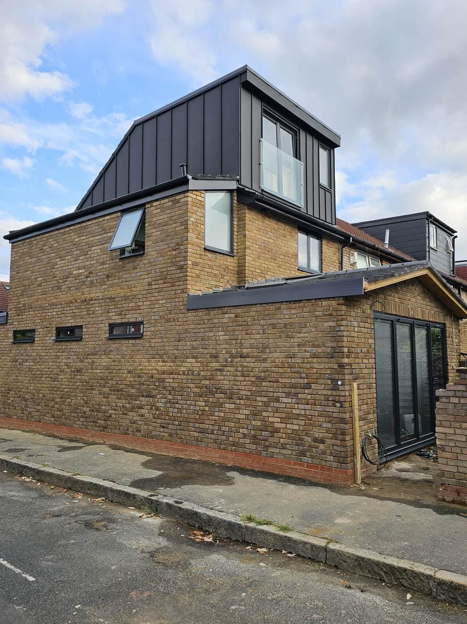 Brick extension with a zinc-clad dormer and glazed doors