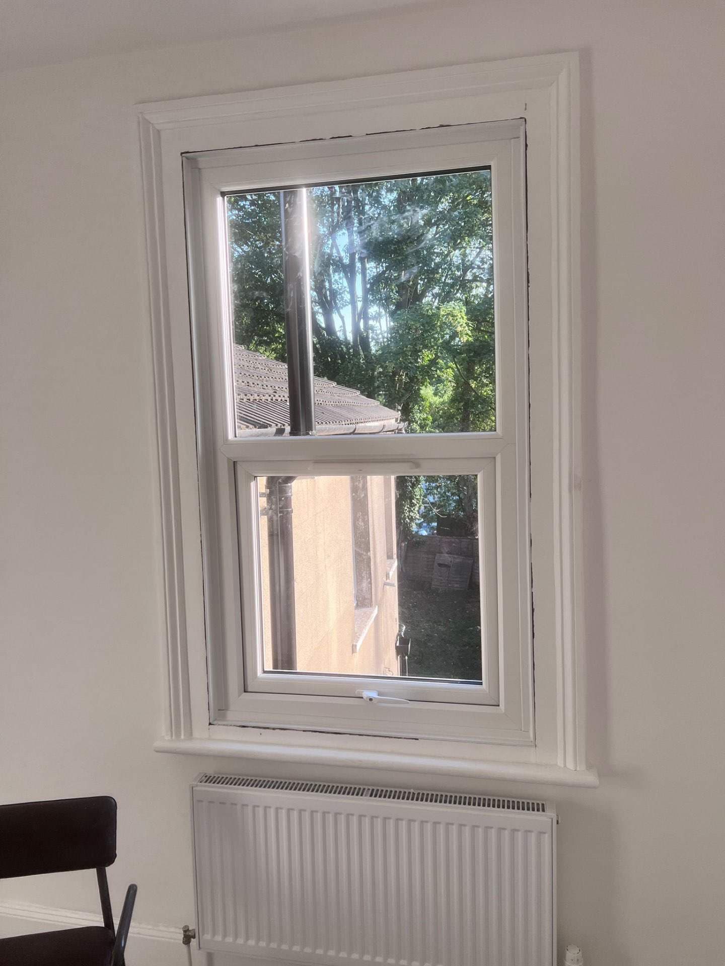 White timber-look sash window inside a painted room