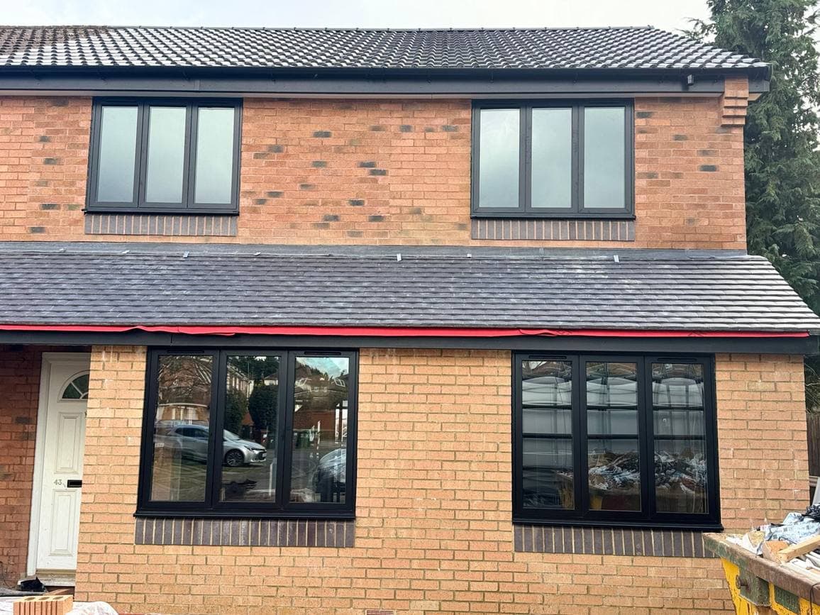 Brick house with new anthracite casement windows on both floors
