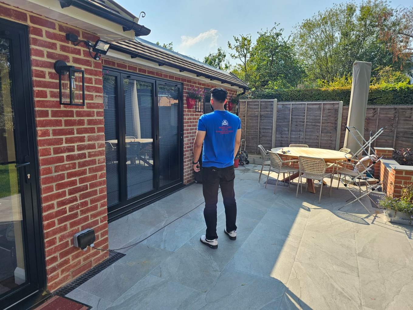 LINX team member on a patio beside newly fitted black sliding doors
