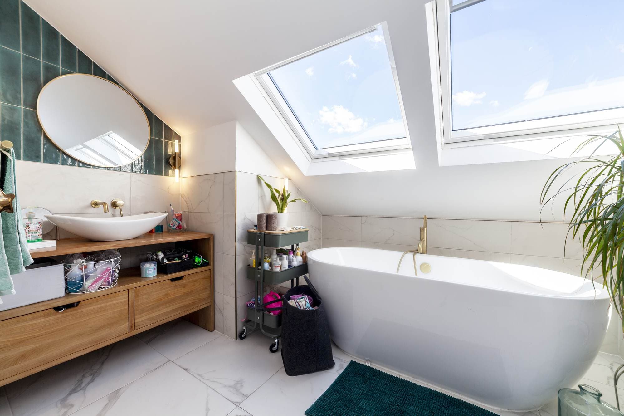 Bathroom with two pitched roof windows above a freestanding bath