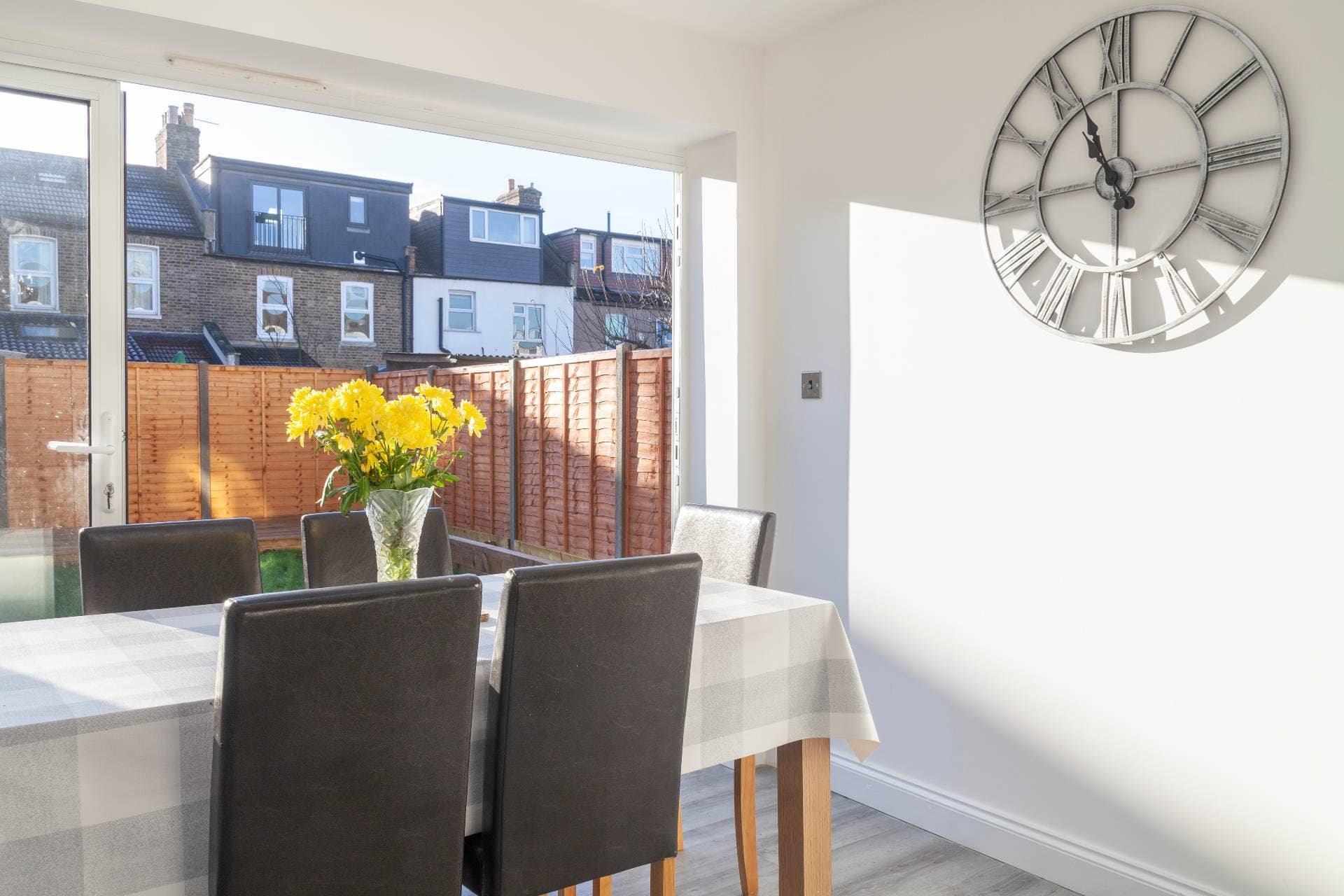 Dining table beside a large window looking over neighbouring rooftops