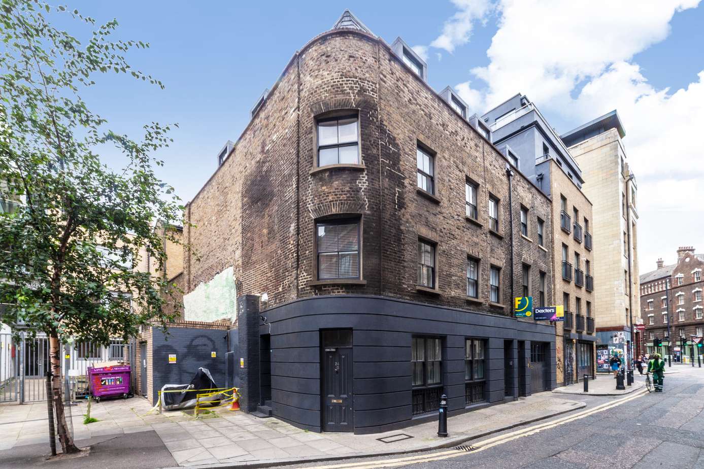 Corner brick building with a black-painted ground floor
