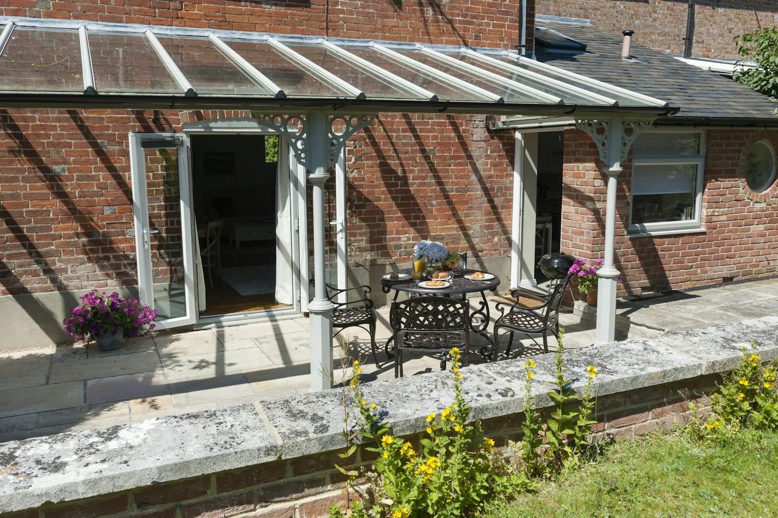 Glass-roofed veranda over a patio on a brick house