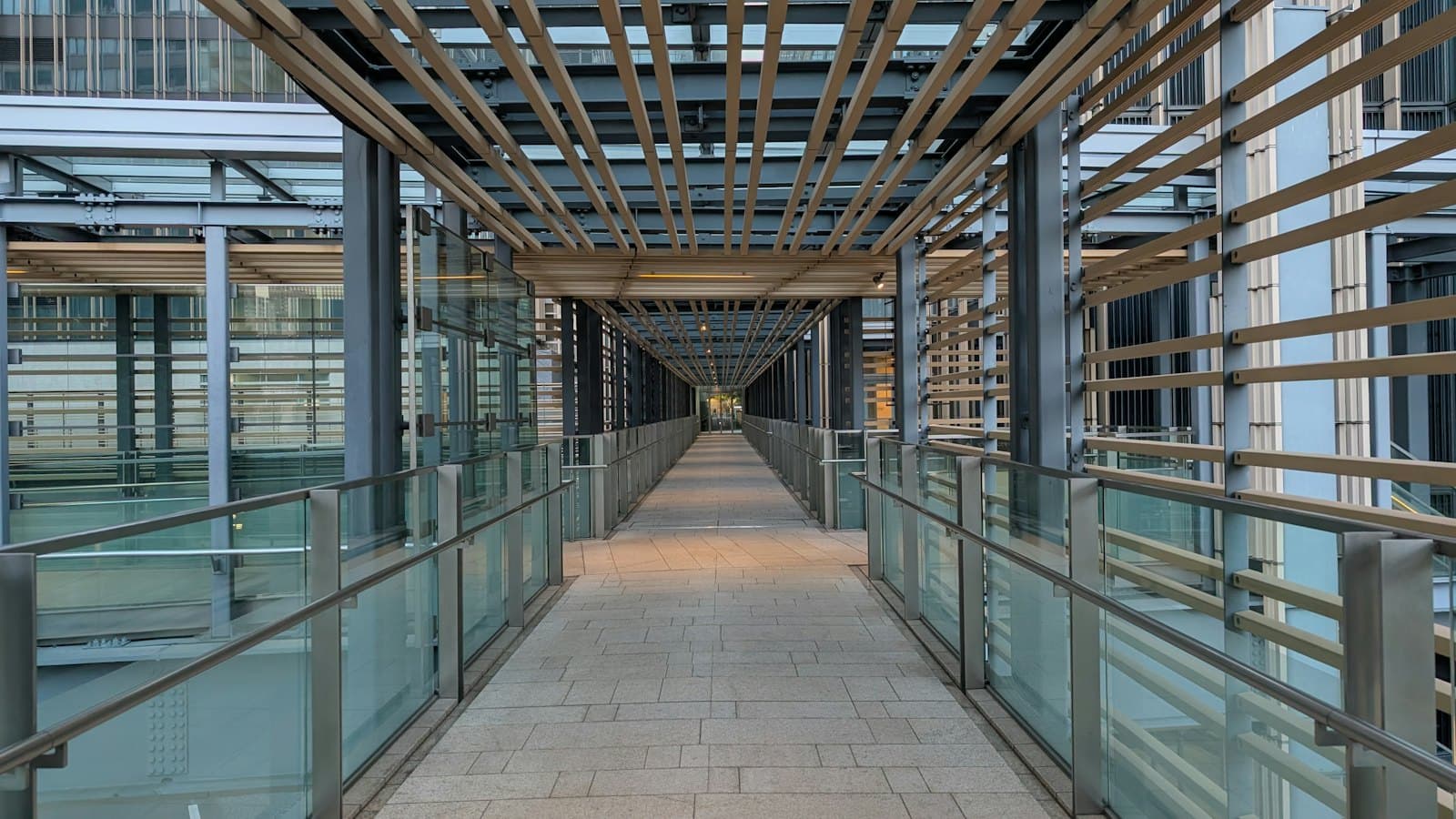 Covered walkway with glass balustrades between buildings